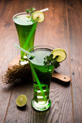 Khus Sharbat or Vetiver Drink served in a glass with Mint and Lemon slice, selective focus