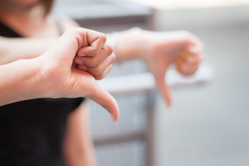 thumb down hand from angry people; women hand showing rejecting thumb down gesture sideway; asian...