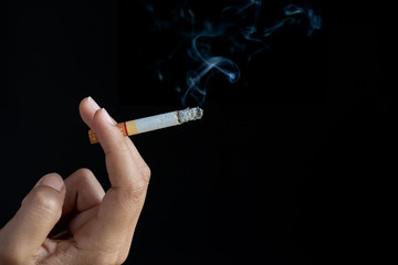 World No Tobacco Day, May 31. STOP Smoking. Close up Man hand holding cigarettes on black background.