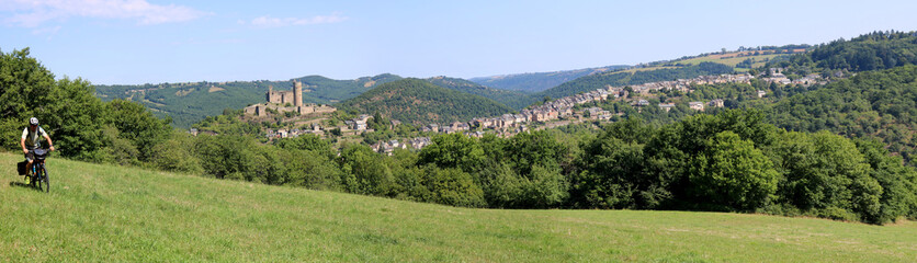 Panorama sur Najac avec un cycliste depuis la colline du Bastit, Aveyron, France