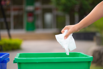 World Environment Day, June 5. Woman hand holding and putting tissue paper waste into garbage trash.