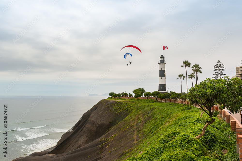 Wall mural lima city coastline and marina iighthouse, with some paragliders in the sky