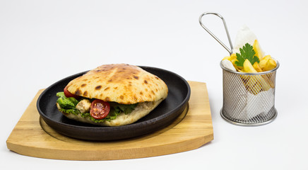 sandwich with chicken pieces, green salad and tomato, decorated with French fries and parsley leaves, white background
