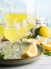 Home made limoncello served in stemmed glasses. Summer still life