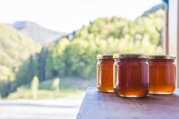 Honig in Honiggl&auml;ser vor bergiger Landschaft