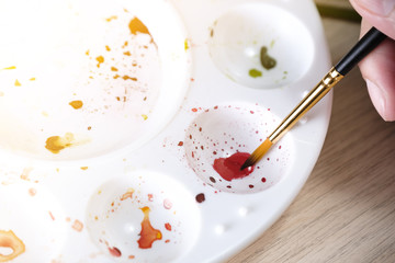 Brush placed on watercolor multiple tray