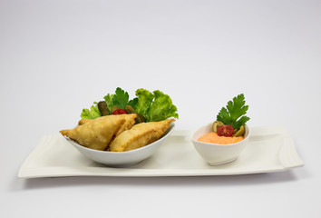 Traditional Arabic Traditional Arabic dish, sausages with decoration of green salads and cucumbers, with sauce of sauce, decorations with green salad and cucumber, with sauce