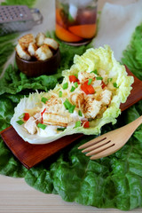 Salad with turkey, baked pepper, croutons and white sauce served in a salad leaf