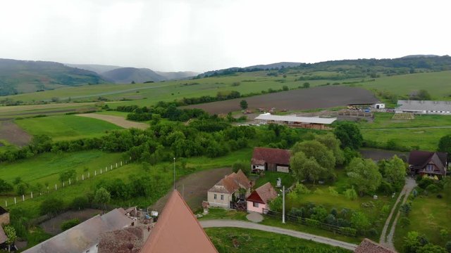 Aerial Drone 4K footage of Traditional village in Transylvania. Cloasterf Village. Medieval old church. in the village, Transylvania, Romania. Austro-Hungarian architecture. The church with a tower
