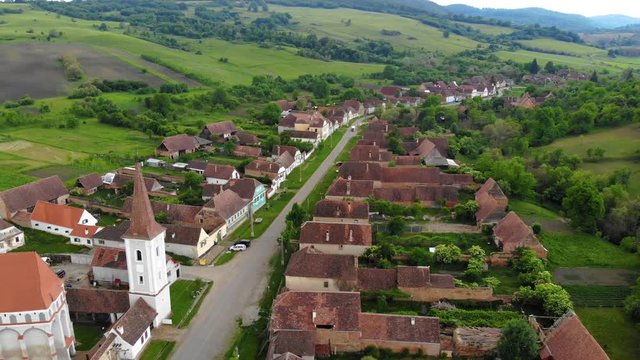 Aerial Drone 4K footage of Traditional village in Transylvania. Cloasterf Village. Medieval old church. in the village, Transylvania, Romania. Austro-Hungarian architecture. The church with a tower
