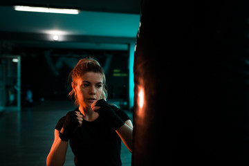 Beautiful woman training with punching bag. Close-up.