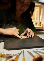Fototapeta premium the engraver applies paste to the medal.
