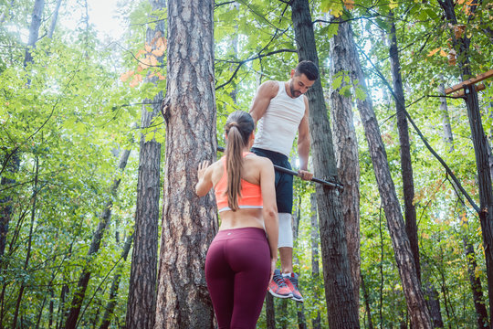 Strong man and athletic woman doing fitness and sport exercise in outdoor gym