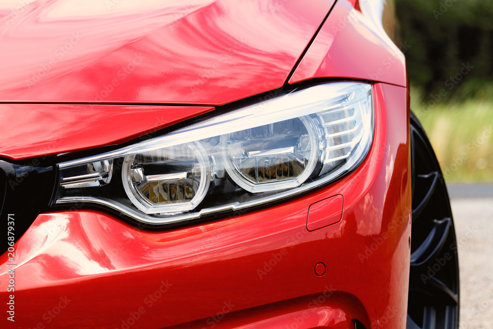 Wall mural Red sports car headlight