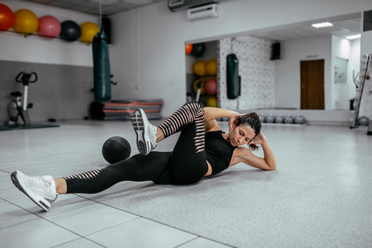 Young Woman Doing Bicycle Crunches At The Gym.