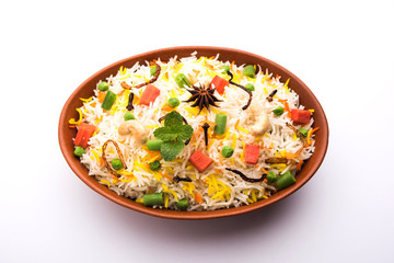 Indian Vegetable Pulav or Biryani made using Basmati Rice, served in a ceramic bowl. selective focus