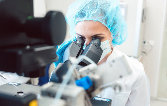 Woman scientist working on microscope in laboratory 