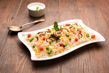 Dabeli is an Indian snack item served with Pomegranate Seeds and Cilantro in white ceramic plate. It's a popular Navratri Festival food