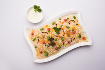 Indian Vegetable Pulav or Biryani made using Basmati Rice, served in a ceramic bowl. selective focus