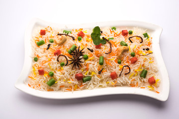Indian Vegetable Pulav or Biryani made using Basmati Rice, served in a ceramic bowl. selective focus