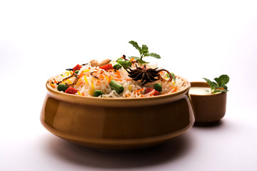 Indian Vegetable Pulav or Biryani made using Basmati Rice, served in a ceramic bowl. selective focus
