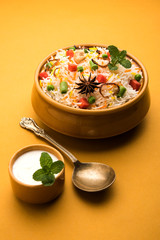 Indian Vegetable Pulav or Biryani made using Basmati Rice, served in a ceramic bowl. selective focus