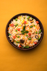 Indian Vegetable Pulav or Biryani made using Basmati Rice, served in a ceramic bowl. selective focus