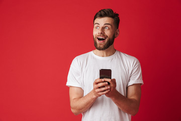 Shocked excited young man using mobile phone.