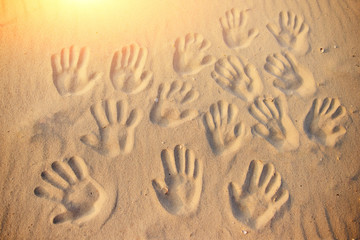 lots of hand prints on the sand