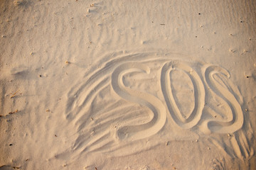 The inscription on the sand beach SOS
