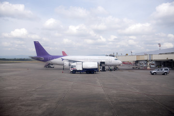 Fototapeta na wymiar Passenger plane parked at the airport waiting to pick up passengers