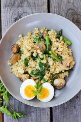 Warm bulgur salad with fried mushrooms, asparagus and spinach