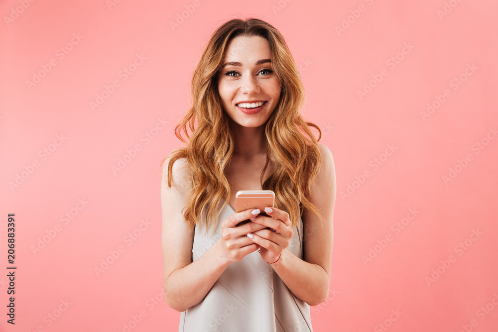 Poster Portrait of a smiling young woman holding mobile phone