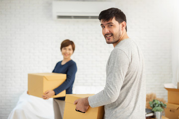 Couple with cardboard boxes at new home.