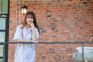 Portrait of happy young female doctor standing and smiling