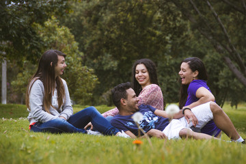 four friends lying on the grass laughing