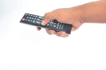 Hand is holding the TV remote to control.