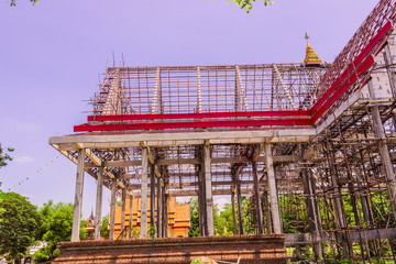 Thai Buddhist church in local of Thailand under construction against the blue sky background