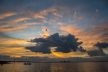 Naklejka na ściany i meble Boat with fishermen at sunrise
