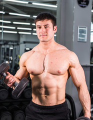 Fototapeta na wymiar Muscular bodybuilder guy in gym