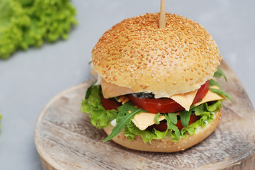 Fast food. Vegetarian Homemade Burger Cheese, Cucumber, Tomato and Lettuce, Salad. Tasty Sandwich for lunch Fresh Vegetables. Gray Textured background