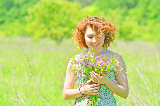 Summer mood. Beautiful woman with wildflowers bouquet outdoors.