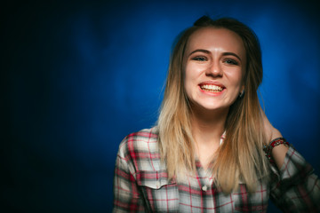 portrait smiling girl on blue background in studio