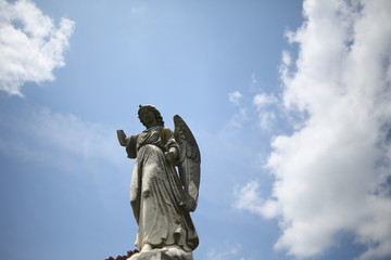 Fototapeta na wymiar Christianity and Religious Iconography Angel Statue Figurine in a Graveyard