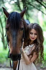 Fototapeta premium portrait of a beautiful girl in a smart dress with a horse close-up