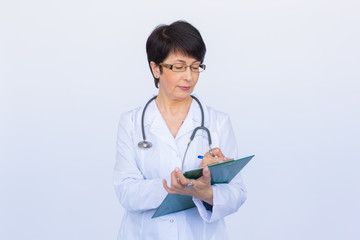 Portrait Of Female Doctor Writing On Clipboard Over a white background