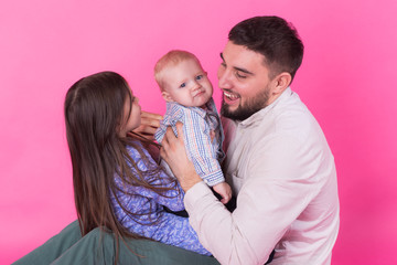 Father with children having fun on pink background