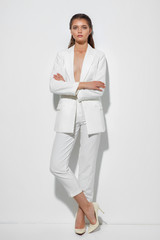 Young woman on a white wall background. High fashion