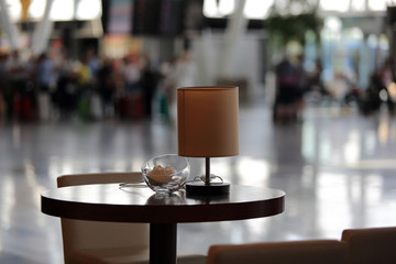 Stolik z lampką w hali portu lotniczego. - obrazy, fototapety, plakaty