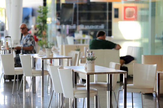Ludzie przy stolikach w restauracji portu lotniczego.